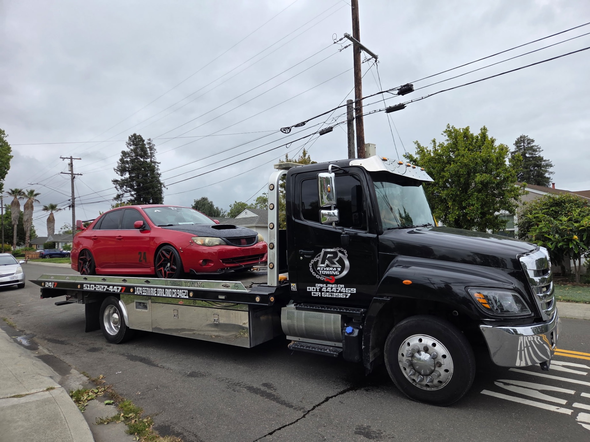 Red Subaru Impreza WRX hauled on Rivera's flatbed in East Bay neighborhood